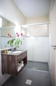 a bathroom with a sink and a shower at Hotel Embaixador in Cruzeiro