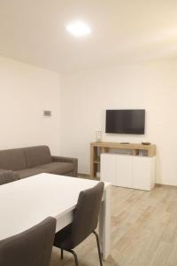 a living room with a table and a flat screen tv at Appartamento San Vitale in Bologna