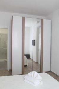 a bedroom with a mirror and a bed with a white bedspread at Appartamento San Vitale in Bologna