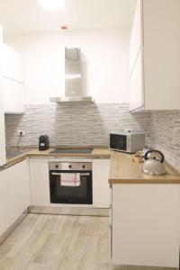 a kitchen with white cabinets and a stove top oven at Appartamento San Vitale in Bologna