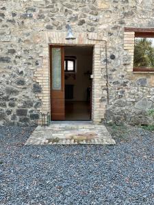 ein Steingebäude mit einer Tür und einem Fenster in der Unterkunft Casadolu 