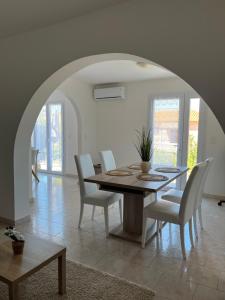 een eetkamer met een tafel en witte stoelen bij Appartement rez de villa in LʼÎle-Rousse