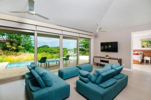 sala de estar con 2 sofás azules y TV en MV-DR61 Casa Buena Vista en Playa Flamingo