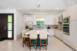 una cocina blanca con mesa y sillas. en MV-DR61 Casa Buena Vista en Playa Flamingo