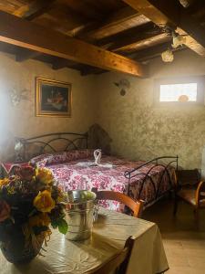 Un dormitorio con una cama y una mesa con flores. en Oasi Rubino en Nettuno