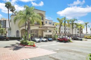 un grand bâtiment avec des voitures garées dans un parking dans l'établissement Hampton Inn & Suites Santa Ana/Orange County Airport, à Santa Ana