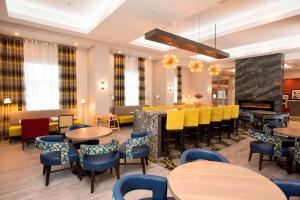 restauracja ze stołami i krzesłami oraz bar w obiekcie Hampton Inn & Suites by Hilton Thunder Bay w mieście Thunder Bay