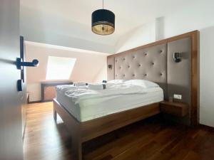 1 dormitorio con 1 cama grande y cabecero grande en Olimian Retreat Rosa 421, en Podčetrtek