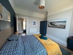 a bedroom with a bed with a blue comforter at St Helens House in Portsmouth