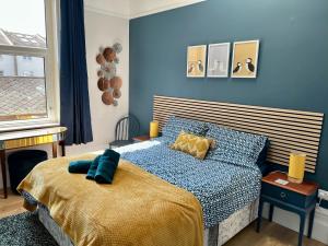 a bedroom with a bed with a blue wall at St Helens House in Portsmouth