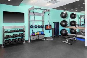 a room with a gym with a television and weights at Tru By Hilton Cleveland Midtown in Cleveland