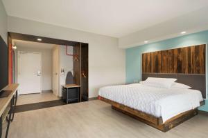 1 dormitorio con 1 cama con cabecero de madera en Tru By Hilton York Pa, en York