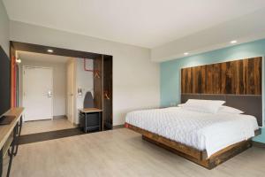 a bedroom with a bed with a wooden headboard at Tru By Hilton York Pa in York