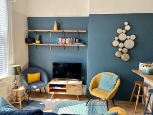 ポーツマスにあるSt Helens Houseの青い壁と椅子、暖炉付きのリビングルーム
