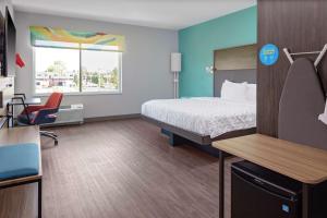クリーブランドにあるTru By Hilton Cleveland Midtownのベッド、デスク、椅子が備わるホテルルームです。
