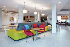 a room with a couch with colorful chairs and tables at Home2 Suites by Hilton Columbia Downtown in Columbia