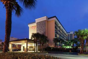 a hotel with palm trees in front of it at Hampton Inn Oceanfront Jacksonville Beach in Jacksonville Beach