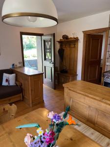 a living room with a table with flowers on it at Appartamento Pelmo in San Vito di Cadore