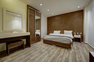 a bedroom with a large bed and a mirror at Luciana Hotel by BRATUS in Aqaba