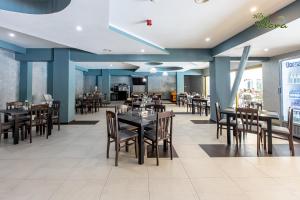 un comedor lleno de mesas y sillas en Hotel Flora, en Mamaia