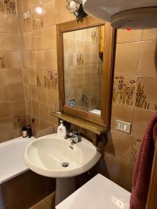 a bathroom with a sink and a mirror and a tub at Appartamento Pelmo in San Vito di Cadore