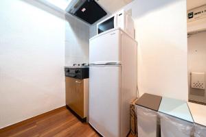 a small kitchen with a refrigerator and a table at Shibuya E Address 303 in Tokyo