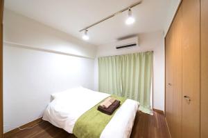 Un dormitorio con una cama con una bolsa. en Shibuya E Address 303, en Tokio