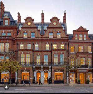 a large brick building with people walking in front of it at Luxury Knightsbridge apartment outside Harrods in London