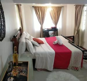 a bedroom with a red and white bed with a window at Beautiful spacious room in Nairobi