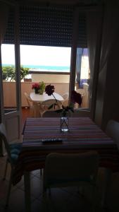 a dining room table with a vase of flowers on it at Lacasadelmare in Francavilla al Mare