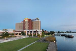 威尔明顿Embassy Suites By Hilton Wilmington Riverfront的靠近水域的大型建筑