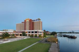 威尔明顿Embassy Suites By Hilton Wilmington Riverfront的靠近水域的大型建筑