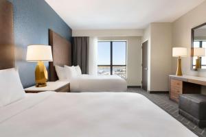 a hotel room with two beds and a window at Embassy Suites By Hilton Wilmington Riverfront in Wilmington