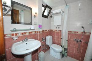a bathroom with a sink and a toilet and a shower at Defne & Zevkim Hotel in Marmaris