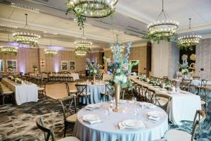威尔明顿Embassy Suites By Hilton Wilmington Riverfront的摆放着白色桌椅和枝形吊灯的宴会厅