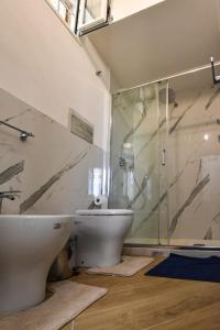a bathroom with a glass shower and a toilet at essegiHome in Porto Empedocle