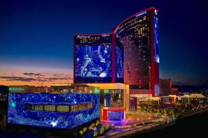 un grand bâtiment avec des lumières bleues allumées la nuit dans l'établissement Conrad Las Vegas At Resorts World, à Las Vegas