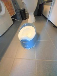 a blue trash can sitting on a bathroom floor next to a toilet at City Apartment 302 in Loviisa