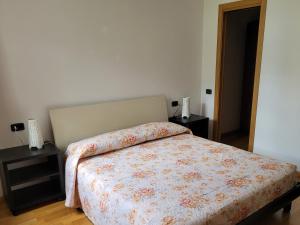 Un dormitorio con una cama con una manta de flores. en Casa IBISCO, en Tenno