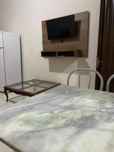 um quarto com uma mesa e uma televisão na parede em Recanto Sonho - PX Palmas Brasil em Palmas
