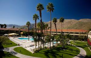 a resort with palm trees and a swimming pool at Hilton Palm Springs in Palm Springs