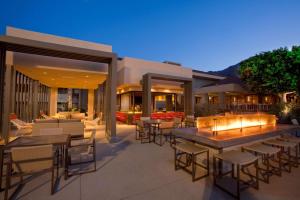 un patio con mesas y sillas por la noche en Hilton Palm Springs en Palm Springs
