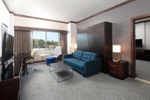 a living room with a blue couch and a television at Hilton Minneapolis Bloomington in Bloomington