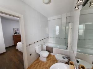 a bathroom with a toilet and a sink and a tub at Ático Intramuros Suites Baeza Monumental in Baeza