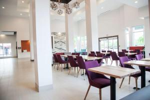 a dining room with tables and purple chairs at Hilton Garden Inn Tampa Suncoast Parkway in Lutz