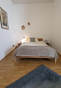 een slaapkamer met een groot bed en een blauw tapijt bij Pension am Park in Pforzheim