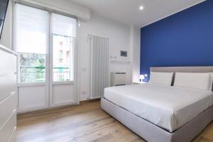 a bedroom with a white bed and a blue wall at Contempora Apartments - bilocale Washington 105 in Milan