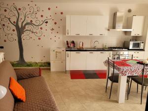 a kitchen with a tree mural on the wall at Casa IBISCO in Tenno