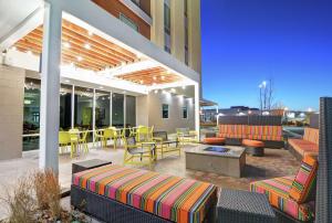 un patio al aire libre con mesas y sillas y un edificio en Home2 Suites By Hilton Grand Junction Northwest, en Grand Junction