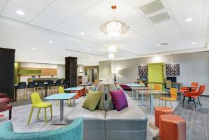 - une salle d'attente avec des tables, des chaises et un canapé dans l'établissement Home2 Suites By Hilton Grand Junction Northwest, à Grand Junction